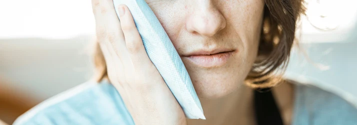 Close-up on a Woman Holding Ice Pack Up To Her Jaw in Pain